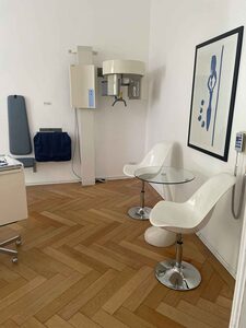 Röntgenraum mit digitalem Röntgengerät und weißen Designstühlen